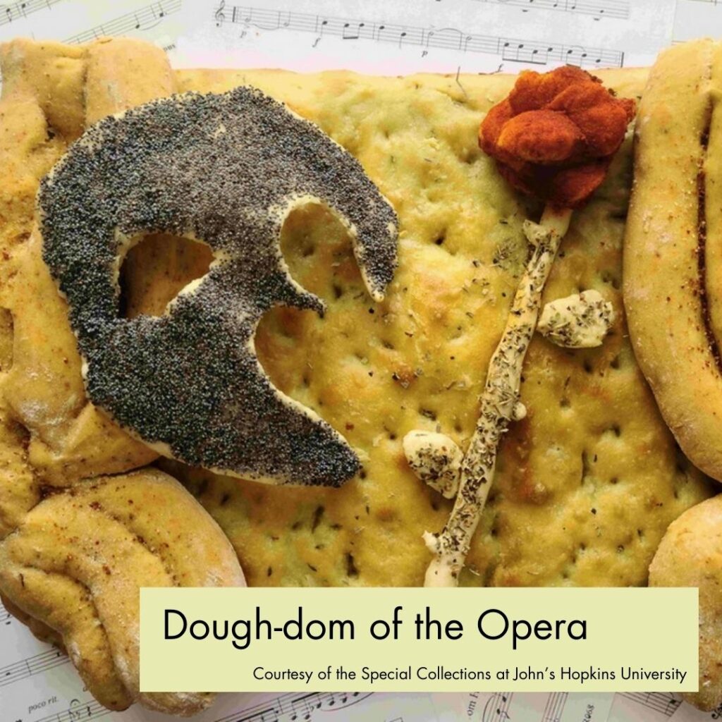 A photograph of focaccia with overlaid curtains, a rose, and a half-mask all made of dough and poppy seeds. In the bottom right, a green rectangle overlays the picture with black text, reading "The Dough-dom of the Opera, Courtesy of the Special Collections at John's Hopkins University."